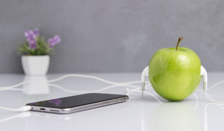 Green Apple with Headset Connected to Phone